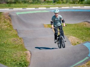 pump track. child on bmx bike rides on pump track.